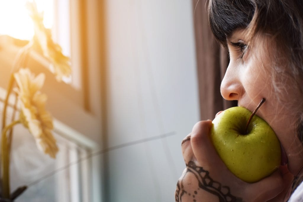 femme croquant dans une pomme verte
